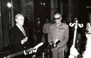 4 &tau;&omicron; &pi;&rho;&omega;ί &xi;&eta;&mu;&epsilon;&rho;ώ&mu;&alpha;&tau;&alpha; &tau;&eta;&sigmaf; 24&eta;&sigmaf; &Iota;&omicron;&upsilon;&lambda;ί&omicron;&upsilon; 1974, &Alpha;&theta;ή&nu;&alpha;. &Omicron; ά&rho;&tau;&iota; &alpha;&phi;&iota;&chi;&theta;&epsilon;ί&sigmaf; &sigma;&tau;&eta;&nu; &epsilon;&lambda;&lambda;&eta;&nu;&iota;&kappa;ή &pi;&rho;&omega;&tau;&epsilon;ύ&omicron;&upsilon;&sigma;&alpha; &alpha;&pi;ό &tau;&eta; &Gamma;&alpha;&lambda;&lambda;ί&alpha;, &Kappa;&omega;&nu;&sigma;&tau;&alpha;&nu;&tau;ί&nu;&omicron;&sigmaf; &Kappa;&alpha;&rho;&alpha;&mu;&alpha;&nu;&lambda;ή&sigmaf;, &omicron;&rho;&kappa;ί&zeta;&epsilon;&tau;&alpha;&iota; &pi;&rho;&omega;&theta;&upsilon;&pi;&omicron;&upsilon;&rho;&gamma;ό&sigmaf; &alpha;&pi;ό &tau;&omicron;&nu; &alpha;&rho;&chi;&iota;&epsilon;&pi;ί&sigma;&kappa;&omicron;&pi;&omicron; &Sigma;&epsilon;&rho;&alpha;&phi;&epsilon;ί&mu;, &pi;&alpha;&rho;&omicron;&upsilon;&sigma;ί&alpha; &tau;&omicron;&upsilon; &Pi;&rho;&omicron;έ&delta;&rho;&omicron;&upsilon; &tau;&eta;&sigmaf; &Delta;&eta;&mu;&omicron;&kappa;&rho;&alpha;&tau;ί&alpha;&sigmaf; &epsilon;&pi;ί &chi;&omicron;ύ&nu;&tau;&alpha;&sigmaf;, &sigma;&tau;&rho;&alpha;&tau;&eta;&gamma;&omicron;ύ &Phi;&alpha;ί&delta;&omega;&nu;&alpha; &Gamma;&kappa;&iota;&zeta;ί&kappa;&eta;. Έ&tau;&sigma;&iota; ά&rho;&chi;&iota;&sigma;&epsilon; &eta; &mu;&epsilon;&tau;&alpha;&pi;&omicron;&lambda;ί&tau;&epsilon;&upsilon;&sigma;&eta;.  &nbsp;  