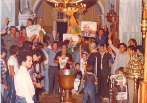 18 Οκτωβρίου 1981, εκκλησία της Παναγίας, Λεχαινά Ηλείας. Ένθερμοι οπαδοί του ΠΑΣΟΚ και του Ανδρέα Παπανδρέου μετατρέπουν τη βάφτιση ενός παιδιού σε ιδιότυπη πασοκική φιέστα της εποχής.